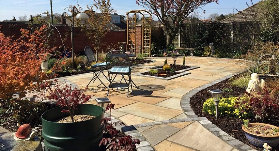 A patio we built surrounded by flower beds.